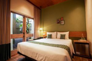 a bedroom with a large bed and a window at Songbird Boutique Inn in Canggu