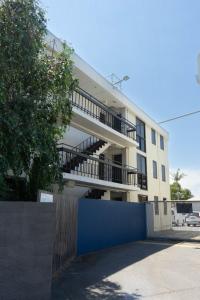an apartment building with balconies and a blue fence at Cosmopolitan Hotel and Apartments in Melbourne