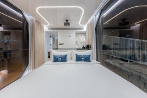 a bedroom with a white bed with blue pillows at Air Space Camp Khao Yai in Pak Chong