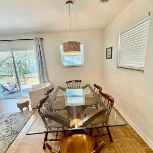 a dining room with a glass table and chairs at Bayfront- 2mins from Boat Launch in Eastpoint
