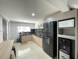 a kitchen with a black refrigerator and a table at Sanur House Lavender in Sanur