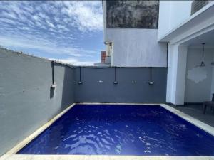 a large blue swimming pool on the side of a building at Sanur House Lavender in Sanur