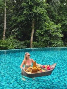 a woman in a boat in a swimming pool at The Ning Resort Ubud in Ubud