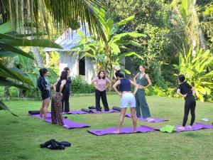 a group of people doing yoga in the grass at The Ning Resort Ubud in Ubud