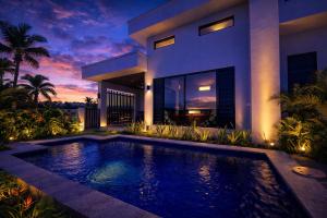 a villa with a swimming pool in front of a house at Solana Properties in Nadi