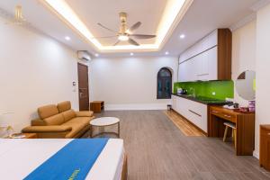 a hotel room with a bed and a living room at Khách sạn đẹp Hà Nội - Royal Louis Hotel in Dại Mõ