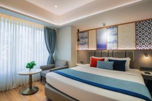 a hotel room with a large bed and a chair at Hotel Silver Inn Near Mumbai Airport in Mumbai