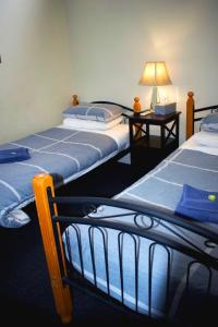 a room with two beds and a table with a lamp at Jack Duggans Pub in Bathurst