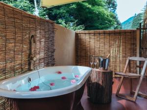 a bath tub sitting on a patio with a chair at La Terra Resort in Shiojiri