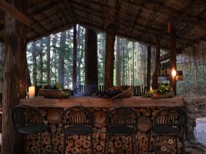 a log cabin with chairs and a table with trees at La Terra Resort in Shiojiri