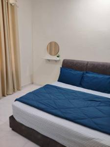 a bed with blue pillows in a room at Infra Homestay 1 in Marang
