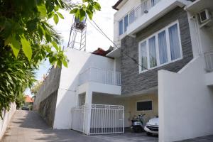 a white building with a tower on top of it at Sanur House Lavender in Sanur