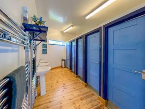 a bathroom with a blue door and a sink at The Bunkhouse - Uk50470 in Greenhaugh +13 photos