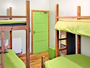 a room with four bunk beds and a green door at The Bunkhouse - Uk50470 in Greenhaugh