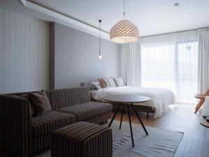 a living room with a bed and a couch and a table at Hotel Espacio 山口 -ADULT ONLY- in Yamaguchi