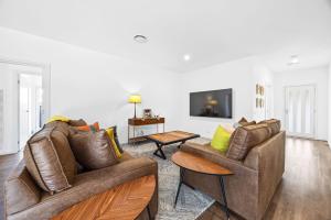 a living room with two couches and a tv at Spacious 4-Bedroom Retreat in Mansfield