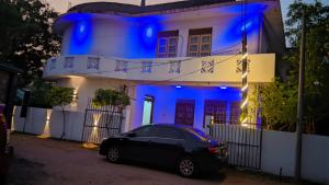 a car parked in front of a house with blue lights at RooLi Harbour Inn-Trincomalee in Trincomalee