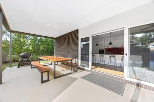 an outdoor patio with a wooden table and a kitchen at Spacious 4-Bedroom Retreat in Mansfield