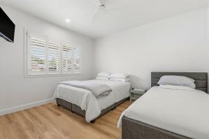 two beds in a room with white walls and a window at Thirty Eight in North Haven