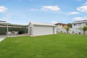 a backyard with a white shed and a lawn at Thirty Eight in North Haven