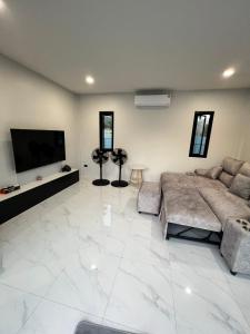 a large living room with a couch and a flat screen tv at The Forest Pool villa & cafe in Ban Wang Yao