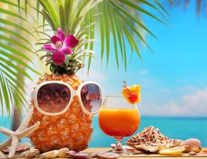 a pineapple vase with sunglasses and a glass of orange juice at Bungalow du Lagon in Ambaro