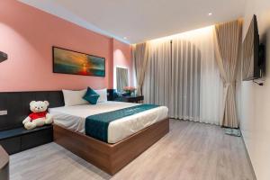 a bedroom with a teddy bear sitting on a bed at Khách sạn XMen Thanh Hóa - Không gần biển in Thanh Hóa