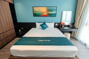 a bedroom with a large bed with a blue wall at Khách sạn XMen Thanh Hóa - Không gần biển in Thanh Hóa