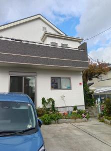 a blue car parked in front of a house at バイキング樫本 in Hirakata