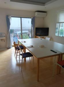 a living room with a large table and chairs at バイキング樫本 in Hirakata