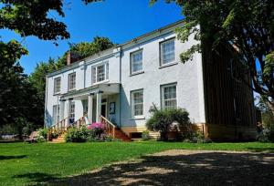 a large white house with a porch and stairs at Manoir Hamilton in New Carlisle