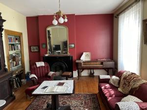 a living room with red walls and a mirror at Manoir Hamilton in New Carlisle +9 photos