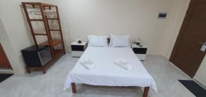 a bedroom with a large white bed with white sheets at Secret Garden Inn in Tagum