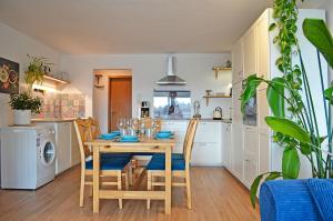 a kitchen with a table and chairs and a kitchen with white cabinets at Wintergarten Wohnung mit Feldblick nahe Legoland in Jettingen-Scheppach +22 photos