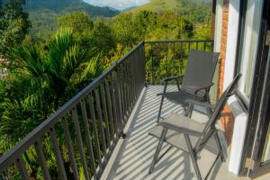 a pair of chairs sitting on a balcony with a view at 3Arch Eco Cottage Ella in Ella