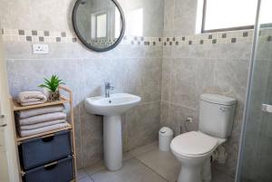 a bathroom with a toilet and a sink and a mirror at Little leisures in Matsapha