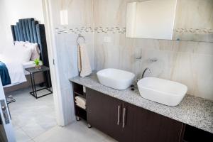 a bathroom with a sink and a mirror on a counter at Little leisures in Matsapha