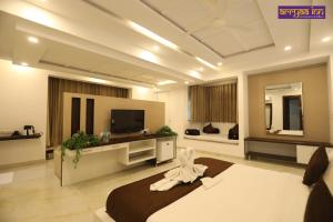 ein großes Zimmer mit einem Bett und einem Fernseher in der Unterkunft Hotel Arrya Inn in Nāi