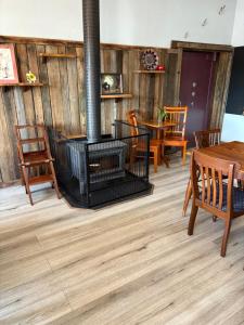 a room with a woodburning stove and tables and chairs at The Bears in Geeveston