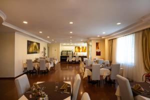 a dining room with white tables and white chairs at Hotel Pushkin in Oral