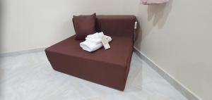 a brown couch with two folded towels on it at Secret Garden Inn in Tagum +30 photos