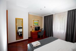 a bedroom with a bed and a desk and a mirror at Hotel Pushkin in Oral +64 photos