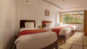 a bedroom with two beds and a window at Seven Machupicchu in Machu Picchu