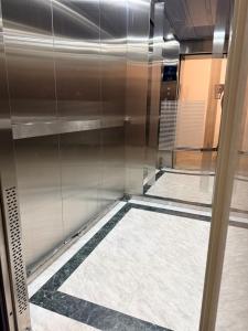 a shower with a glass door in a bathroom at Atamura 1 in Karagandy