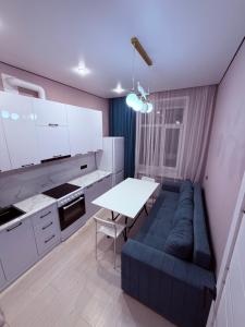 a living room with a blue couch and a table at Atamura 1 in Karagandy