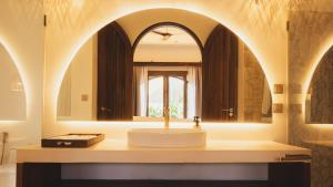 a bathroom with a sink and a mirror at Sunyata Resort Siargao in Catagnan