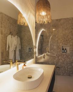 a bathroom with a sink and a bath tub at Sunyata Resort Siargao in Catagnan