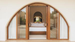 a bedroom with an arched doorway with a bed inside at Sunyata Resort Siargao in Catagnan