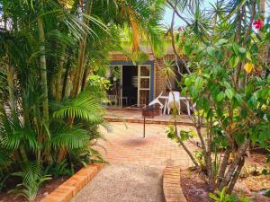 a house with a brick patio and palm trees at The Estuary Guest Chalets in St Lucia