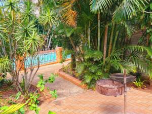 a patio with a table and trees and a pool at The Estuary Guest Chalets in St Lucia